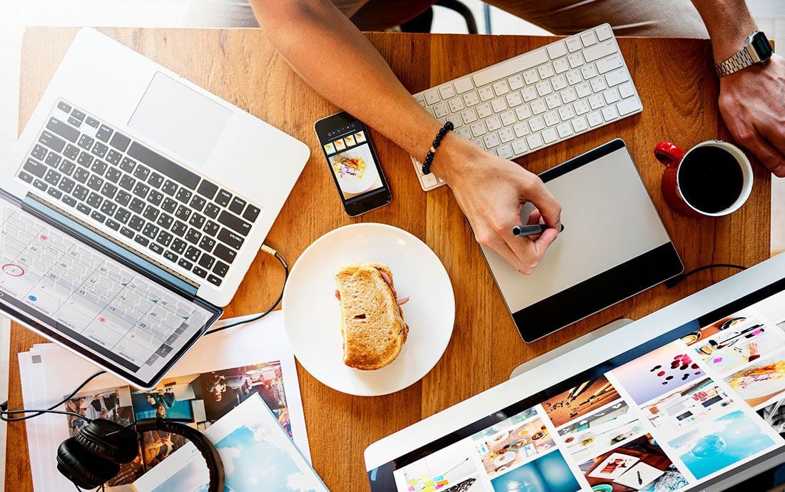 Business owner comparing sales figures and an advertising budget on a laptop