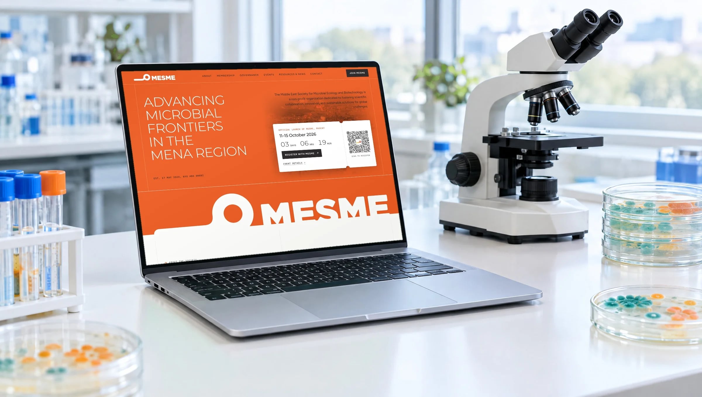 The MEsME home page on a laptop on a lab bench beside a microscope