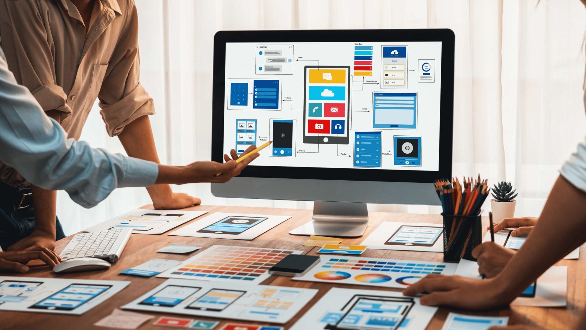 Designer and developer reviewing a mobile checkout screen on a phone and laptop
