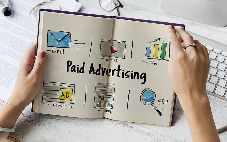Media buyer reviewing ad spend and return figures on two monitors