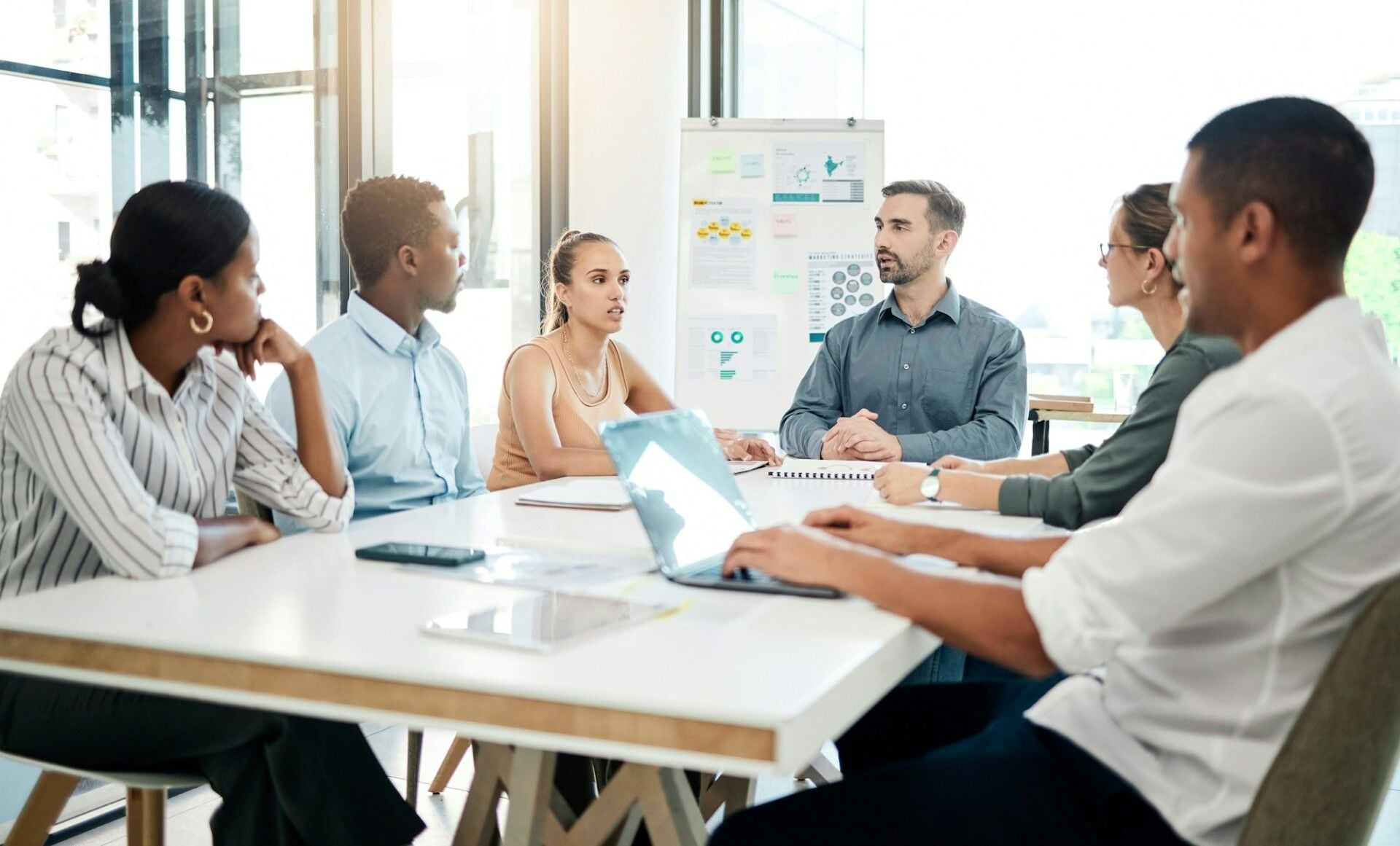 Small startup team gathered around a laptop planning their first online campaign